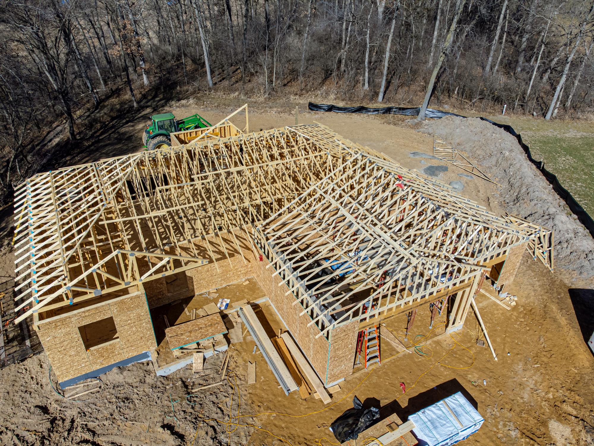 Aerial view of a new house being framed with roof trusses